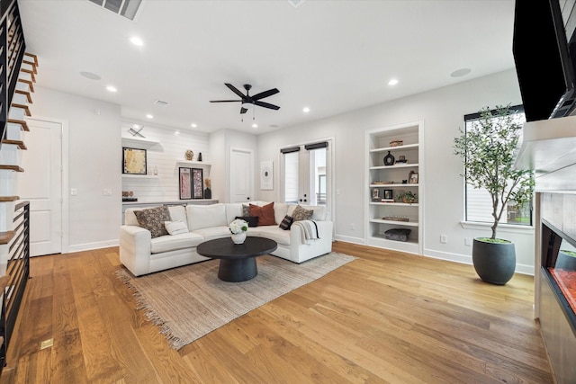 824 Wakefield Dr Unit A, Houston, TX 77018 - living room with a glass covered fireplace, built in shelves, a ceiling fan, light wood finished floors, and recessed lighting