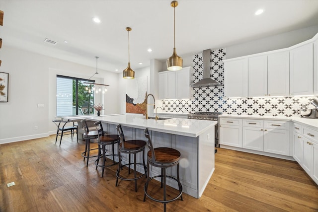 824 Wakefield Dr Unit A, Houston, TX 77018 - kitchen with wall chimney exhaust hood, electric stove, tasteful backsplash, light countertops, and a center island with sink