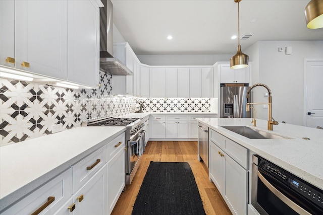 824 Wakefield Dr Unit A, Houston, TX 77018 - kitchen with appliances with stainless steel finishes, wall chimney range hood, light wood-type flooring, white cabinetry, and backsplash