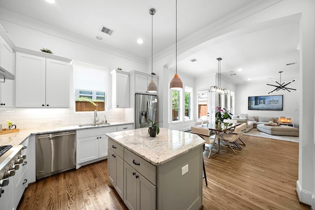 8421 Moritz Grn, Houston, TX 77055 - kitchen with appliances with stainless steel finishes, crown molding, decorative backsplash, a center island, and open floor plan