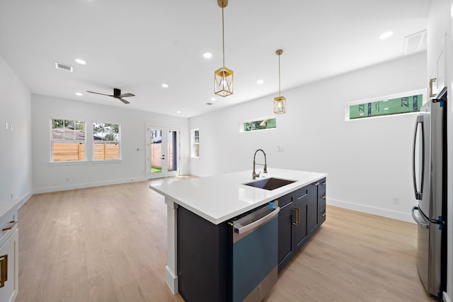 1305 Amundsen St N, Houston, TX 77009 - kitchen featuring dishwashing machine, freestanding refrigerator, recessed lighting, light wood-style flooring, and pendant lighting