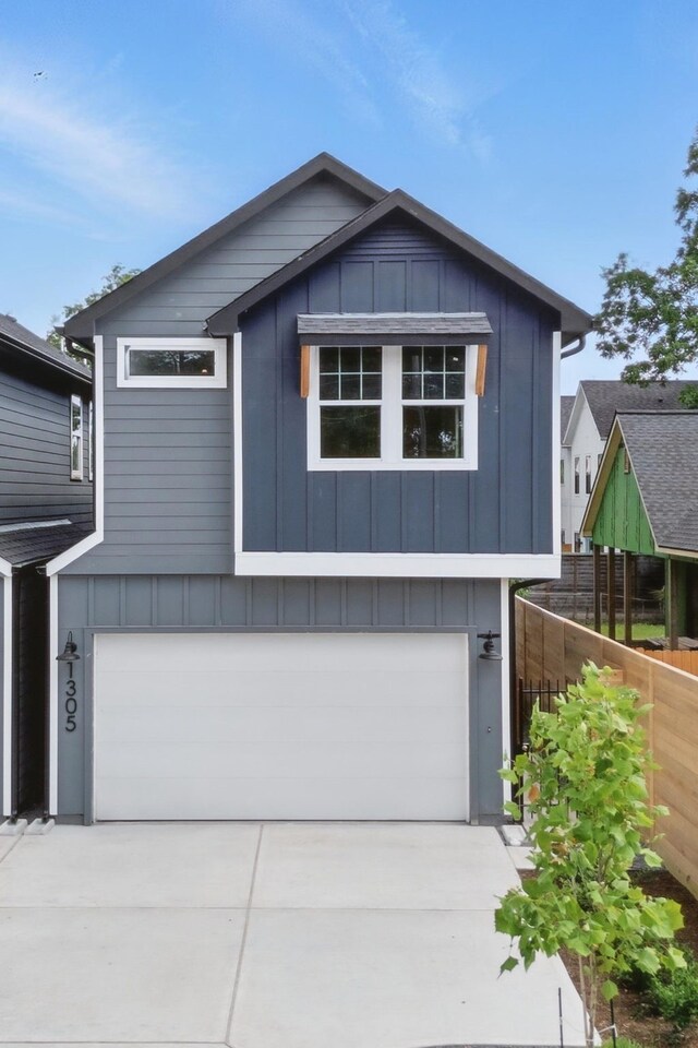 1305 Amundsen St N, Houston, TX 77009 - view of front of house featuring a garage, concrete driveway, and board and batten siding