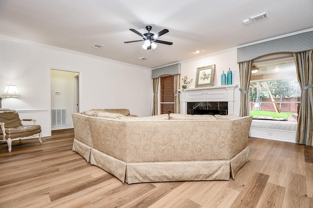 7014 Greatwood Trails Ct, Sugar Land, TX 77479 - living area with ornamental molding, a ceiling fan, light wood-style flooring, and a tiled fireplace