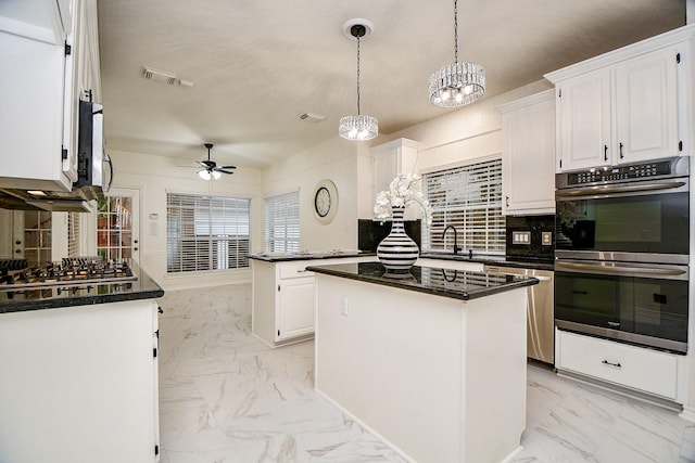 7014 Greatwood Trails Ct, Sugar Land, TX 77479 - kitchen featuring stainless steel appliances, light marble finish floors, a ceiling fan, dark countertops, and white cabinets
