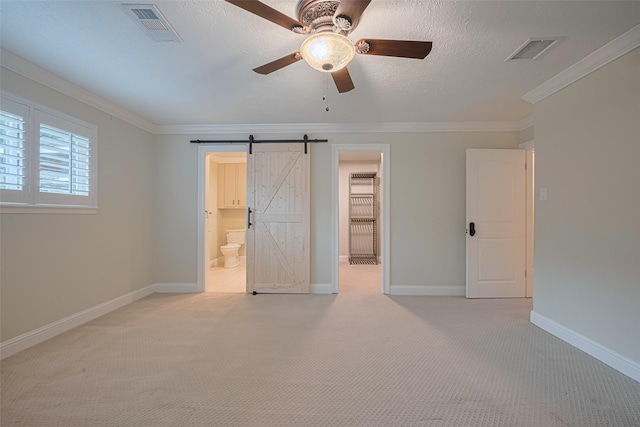 11710 Hillcroft St, Houston, TX 77035 - unfurnished bedroom with a barn door, crown molding, a spacious closet, light carpet, and a ceiling fan