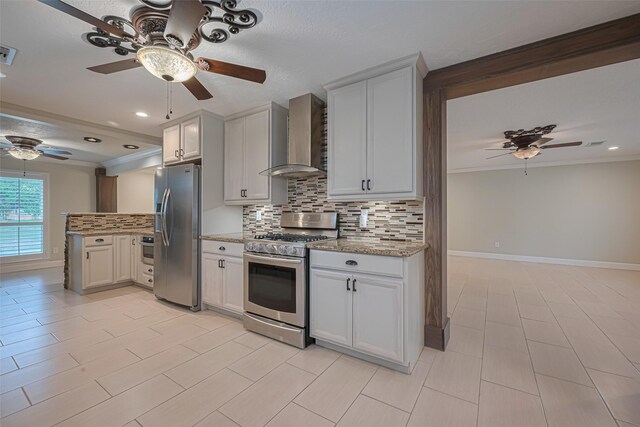 11710 Hillcroft St, Houston, TX 77035 - kitchen with stainless steel appliances, wall chimney exhaust hood, a ceiling fan, backsplash, and light stone counters