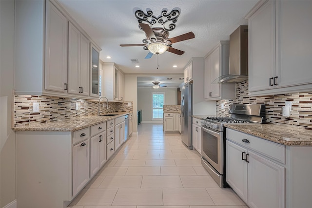 11710 Hillcroft St, Houston, TX 77035 - kitchen with stainless steel appliances, ceiling fan, wall chimney range hood, decorative backsplash, and glass insert cabinets