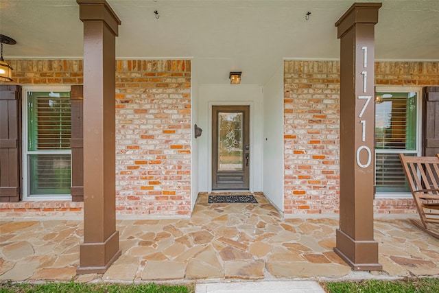 11710 Hillcroft St, Houston, TX 77035 - doorway to property featuring covered porch and brick siding