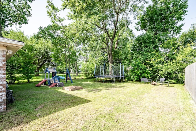 322 S Carroll, La Porte, TX 77571 - fenced backyard with a trampoline, a playground, and view of scattered trees