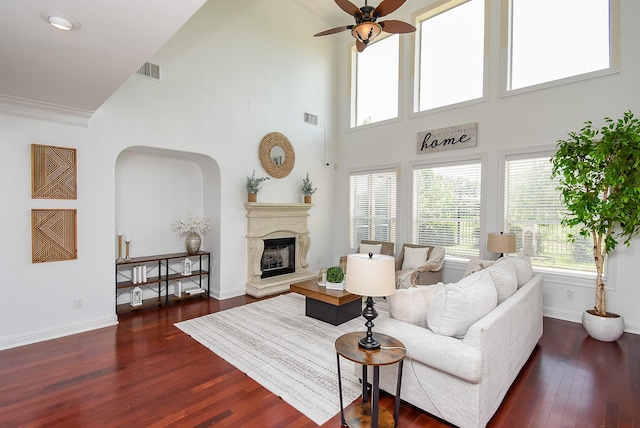 7010 Mcclellan Ln, Sugar Land, TX 77479 - living area featuring plenty of natural light, dark wood-type flooring, a ceiling fan, a towering ceiling, and arched walkways