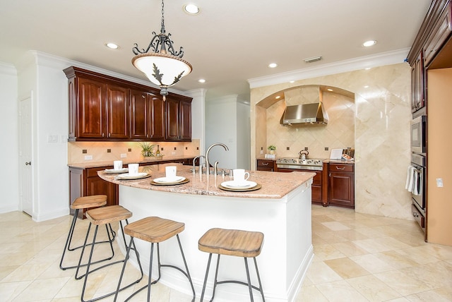 7010 Mcclellan Ln, Sugar Land, TX 77479 - kitchen with wall chimney exhaust hood, crown molding, a breakfast bar, light stone countertops, and tasteful backsplash