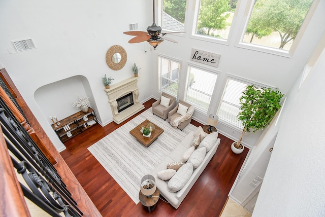 7010 Mcclellan Ln, Sugar Land, TX 77479 - living room with a high ceiling, ceiling fan, a premium fireplace, and wood finished floors