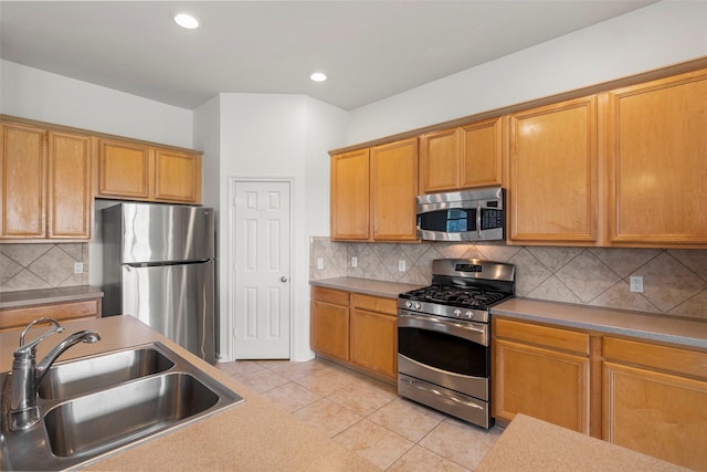12610 Hobbs Terrace Dr, Tomball, TX 77377 - kitchen with stainless steel appliances, light tile patterned flooring, backsplash, recessed lighting, and brown cabinets
