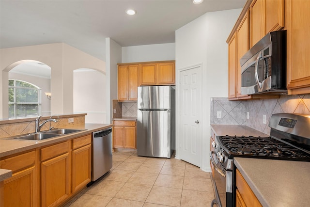 12610 Hobbs Terrace Dr, Tomball, TX 77377 - kitchen featuring stainless steel appliances, arched walkways, decorative backsplash, recessed lighting, and light tile patterned floors
