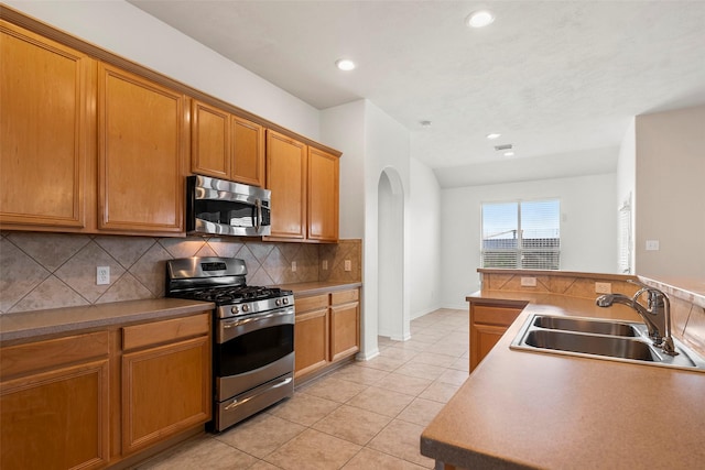 12610 Hobbs Terrace Dr, Tomball, TX 77377 - kitchen featuring stainless steel appliances, arched walkways, decorative backsplash, light tile patterned floors, and recessed lighting