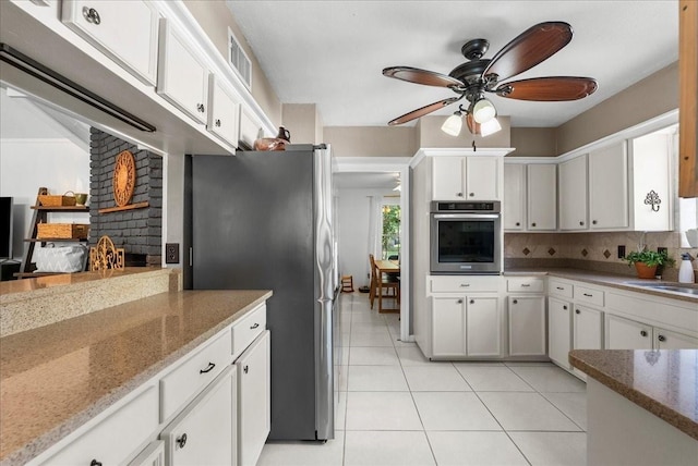 431 Shadow Creek Dr, El Lago, TX 77586 - kitchen featuring stainless steel appliances, a ceiling fan, light tile patterned floors, backsplash, and white cabinets