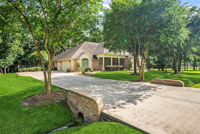 1114 Commons Waterway Dr, Huffman, TX 77336 - view of front of property with concrete driveway, brick siding, a front lawn, and an attached garage