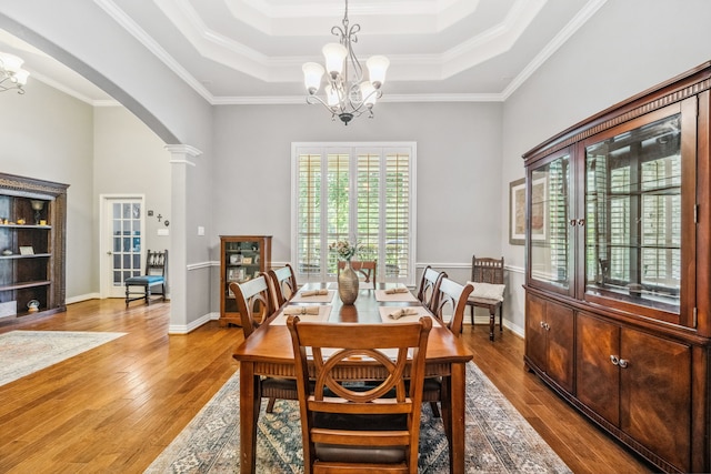 1114 Commons Waterway Dr, Huffman, TX 77336 - dining area with arched walkways, a chandelier, hardwood / wood-style flooring, a tray ceiling, and crown molding