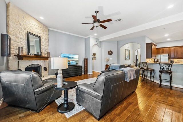 1114 Commons Waterway Dr, Huffman, TX 77336 - living area with arched walkways, ceiling fan, dark wood finished floors, a fireplace, and ornamental molding