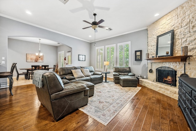 1114 Commons Waterway Dr, Huffman, TX 77336 - living room with arched walkways, dark wood-style floors, a stone fireplace, a ceiling fan, and recessed lighting