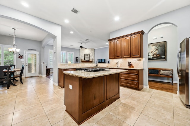 1114 Commons Waterway Dr, Huffman, TX 77336 - kitchen with appliances with stainless steel finishes, light tile patterned floors, backsplash, a center island, and recessed lighting