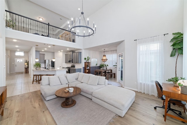 18534 Tall Woods Pl, Houston, TX 77084 - living room with a high ceiling, light wood-style flooring, healthy amount of natural light, and a chandelier