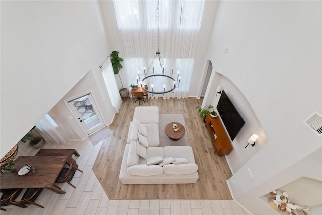 18534 Tall Woods Pl, Houston, TX 77084 - living room with a high ceiling, a chandelier, wood finished floors, and arched walkways