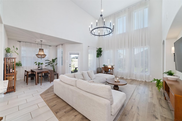 18534 Tall Woods Pl, Houston, TX 77084 - living area with a chandelier, a high ceiling, arched walkways, and light wood finished floors