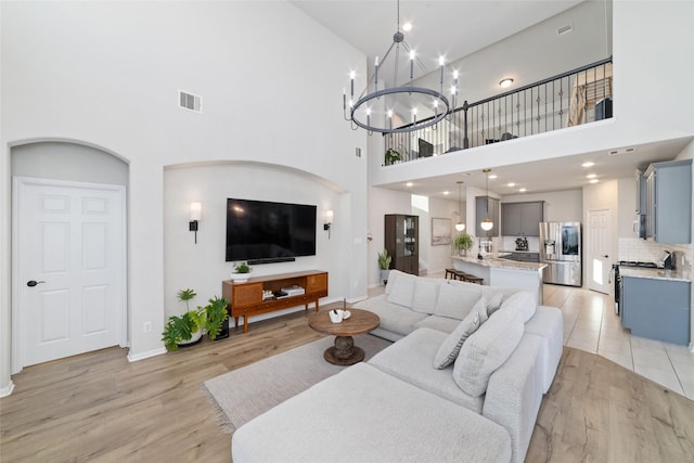 18534 Tall Woods Pl, Houston, TX 77084 - living room with a towering ceiling, light wood finished floors, and a chandelier