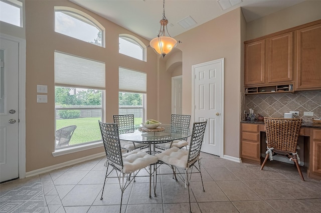 15902 Mill Canyon Ct, Cypress, TX 77429 - dining space featuring light tile patterned floors, built in study area, arched walkways, and a high ceiling