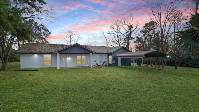 242 Bishop, Livingston, TX 77351 - back of property at dusk featuring a carport and a lawn