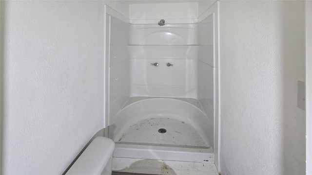 242 Bishop, Livingston, TX 77351 - bathroom featuring a shower and a textured wall