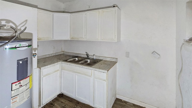 242 Bishop, Livingston, TX 77351 - kitchen featuring water heater, white cabinetry, dark wood finished floors, and light countertops