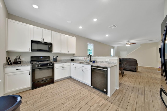 24715 Winema Woods Ln, Huffman, TX 77336 - kitchen featuring black appliances, a peninsula, white cabinets, and recessed lighting