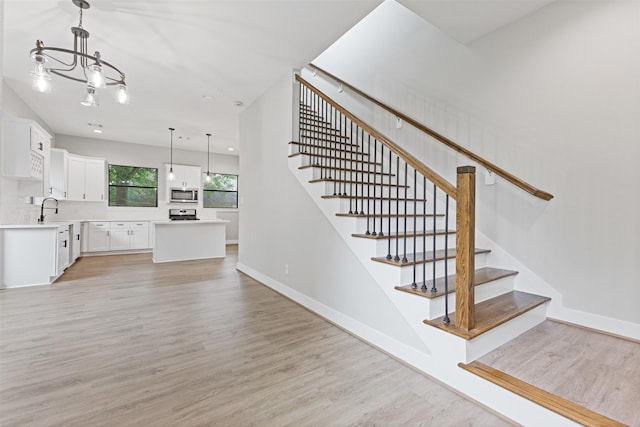 806 E 39th St Unit A, Houston, TX 77022 - stairway with wood finished floors and a chandelier