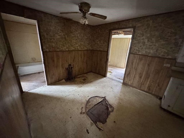509 N Waggoner St, Electra, TX 76360 - spare room with wainscoting, ceiling fan, and wood walls