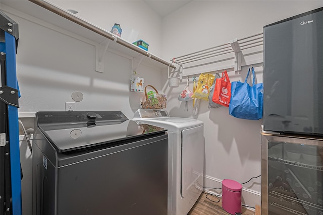 9011 Bright Harbor Dr, Cypress, TX 77433 - washroom featuring separate washer and dryer and wood finished floors
