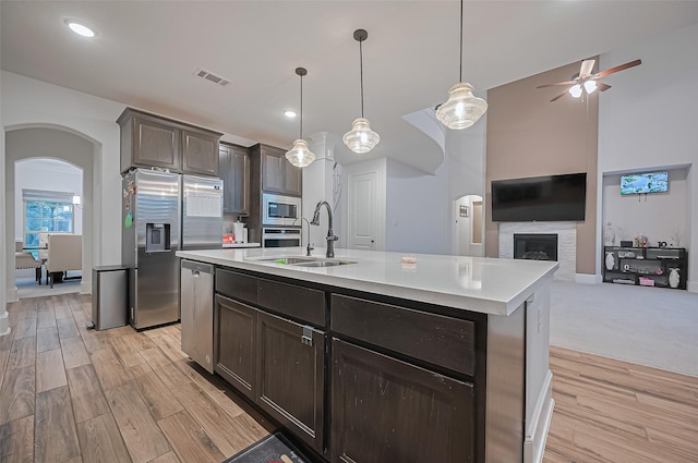 9011 Bright Harbor Dr, Cypress, TX 77433 - kitchen featuring appliances with stainless steel finishes, arched walkways, light countertops, light wood-type flooring, and recessed lighting