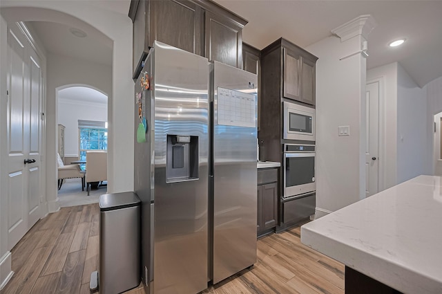 9011 Bright Harbor Dr, Cypress, TX 77433 - kitchen with appliances with stainless steel finishes, arched walkways, light wood-type flooring, dark brown cabinets, and recessed lighting
