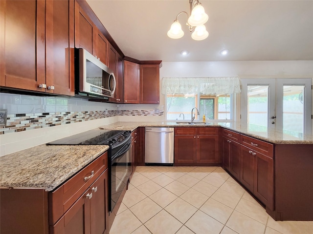17602 Kakerglen Ct, Houston, TX 77084 - kitchen featuring stainless steel appliances, a peninsula, backsplash, a chandelier, and light stone counters