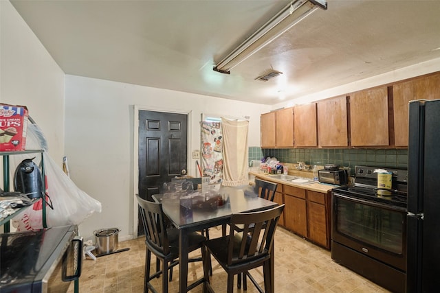 3214 Stallings Dr, Houston, TX 77088 - kitchen featuring black appliances, decorative backsplash, brown cabinets, and light floors