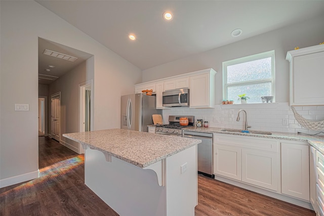 6418 Gresham St, Wallis, TX 77485 - kitchen with appliances with stainless steel finishes, a center island, white cabinets, backsplash, and light stone counters