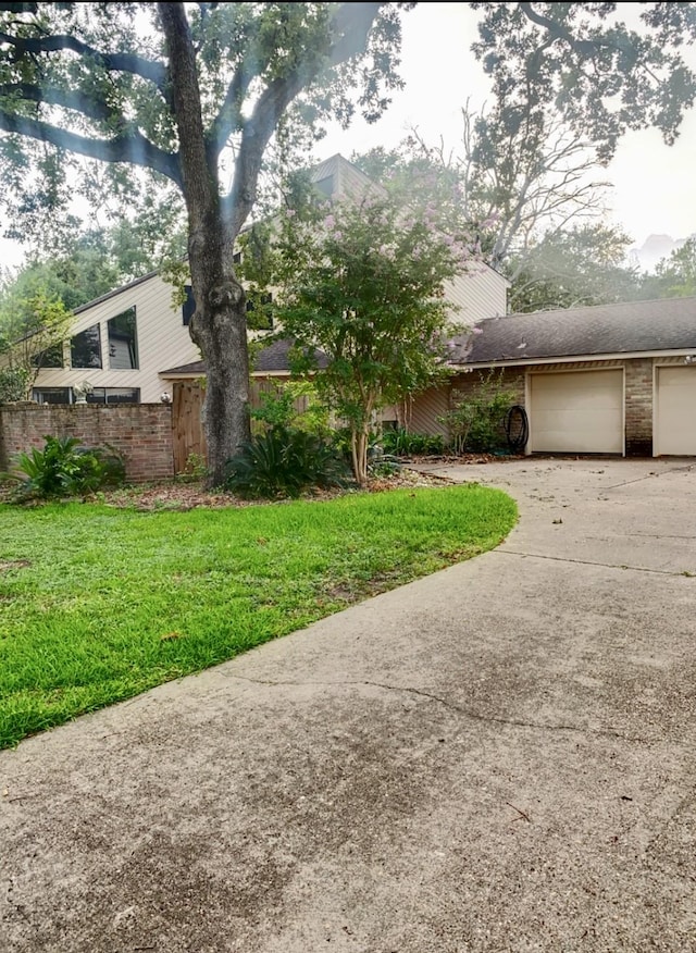 16510 De Lozier St, Jersey Village, TX 77040 - mid-century inspired home featuring a garage, concrete driveway, brick siding, and roof with shingles