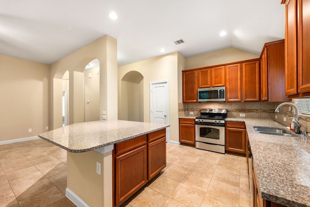 12818 Bridle Springs Ln, Houston, TX 77044 - kitchen with stainless steel appliances, arched walkways, backsplash, light stone countertops, and recessed lighting