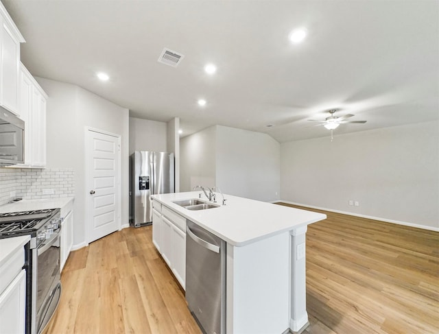 21622 Teton Rock Trl, Richmond, TX 77407 - kitchen featuring appliances with stainless steel finishes, ceiling fan, a kitchen island with sink, recessed lighting, and light wood-style floors