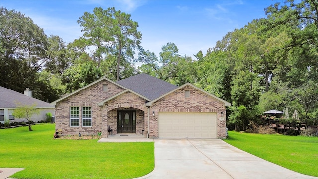 224 Evergreen Dr, Huntsville, TX 77340 - view of front facade with brick siding, a garage, driveway, and a front yard