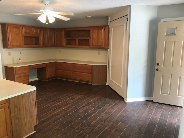1311 Antoine Dr Unit 159, Houston, TX 77055 - kitchen with open shelves, built in desk, a ceiling fan, dark wood-type flooring, and a textured ceiling