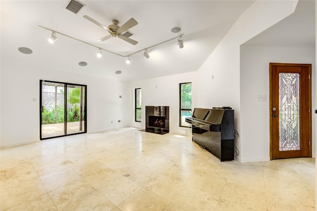 3831 Wood Stone Walk Dr, Houston, TX 77084 - unfurnished living room featuring rail lighting, a ceiling fan, a fireplace with flush hearth, and tile patterned floors