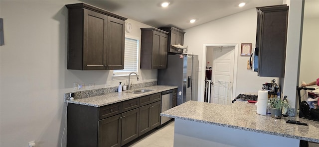5311 New Iberia Ln, Dickinson, TX 77539 - kitchen featuring dark brown cabinetry, a peninsula, lofted ceiling, appliances with stainless steel finishes, and light stone countertops