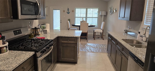 5311 New Iberia Ln, Dickinson, TX 77539 - kitchen featuring stainless steel appliances, dark brown cabinetry, a peninsula, and light stone counters